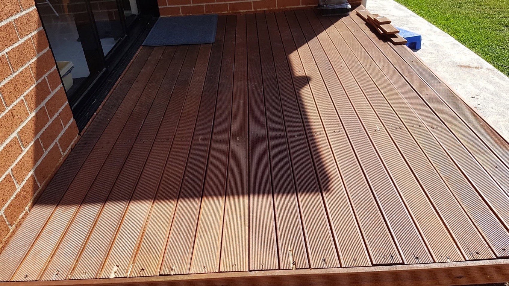 A freshly laid hardwood deck stained a deep red-brown