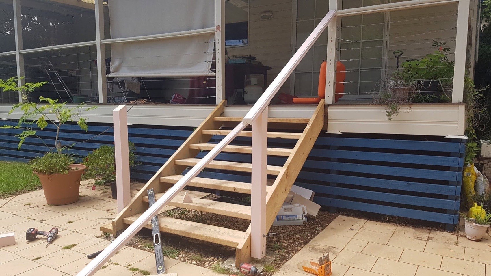 A new timber staircase being fitted against the side of a house