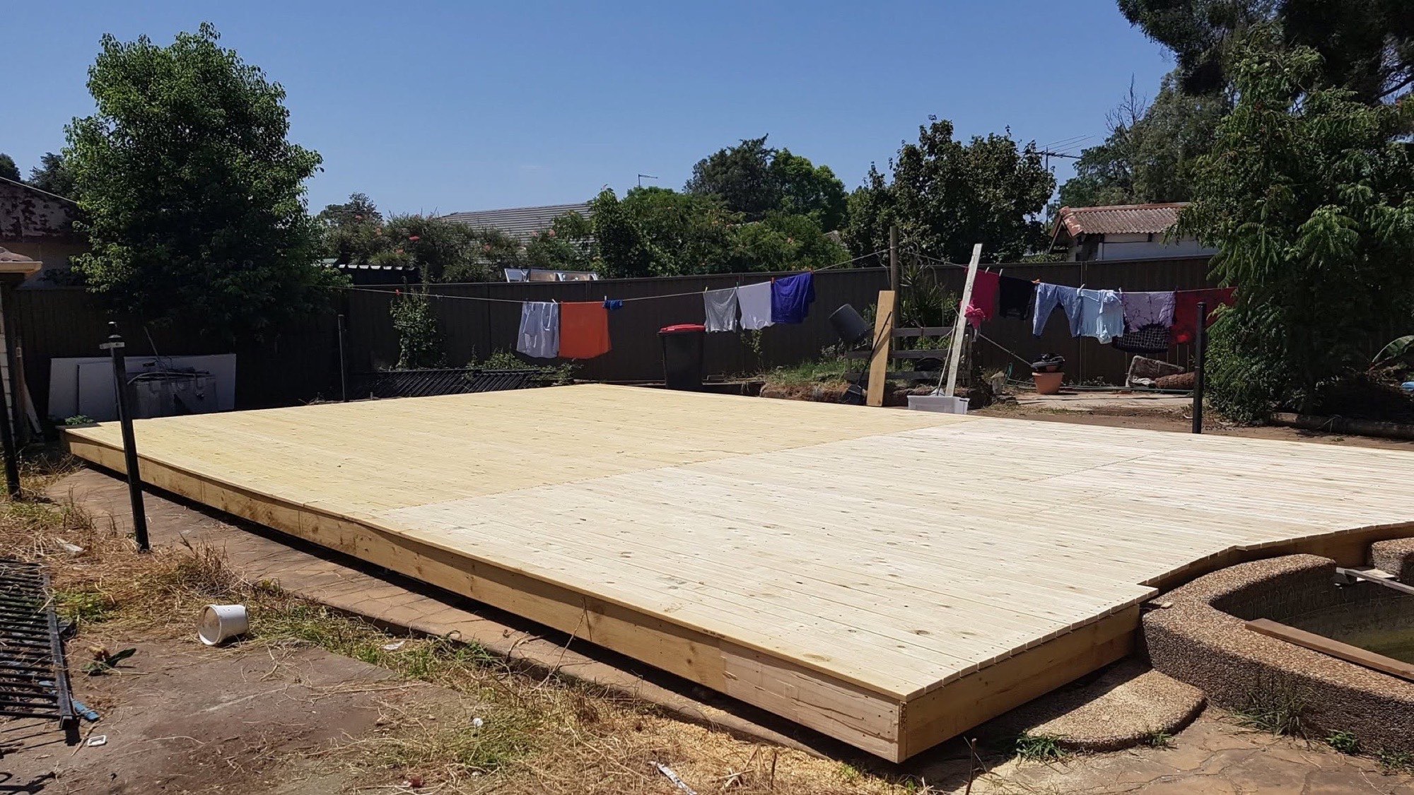 A large new timber deck platform built across a Bundaberg backyard under a clear sky