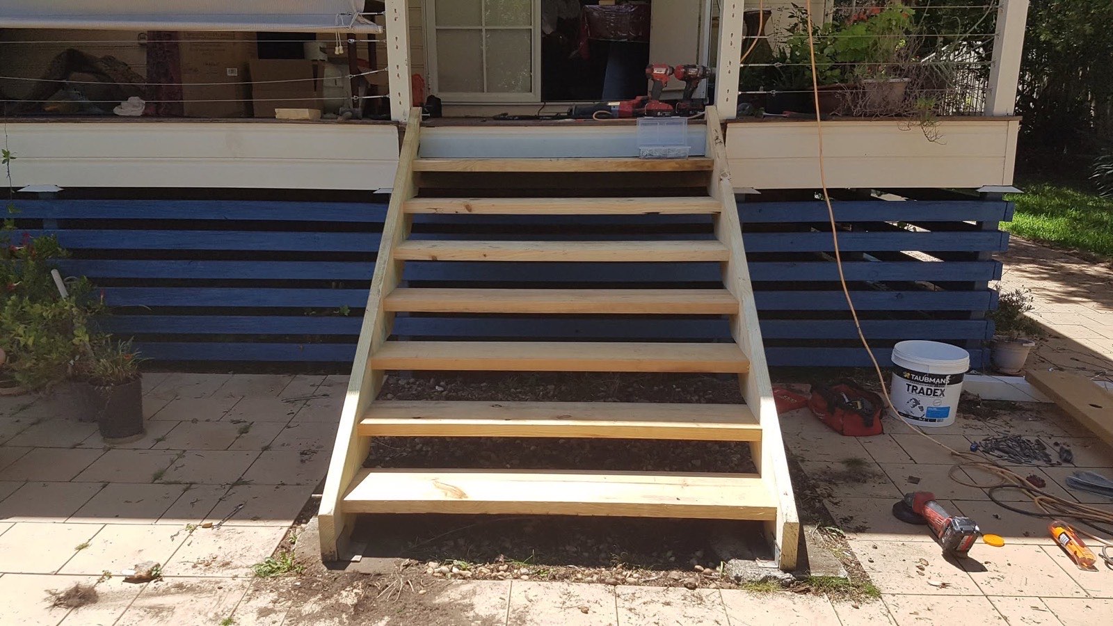 A new set of timber stairs built up to the front deck of a house