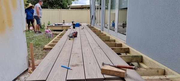 New decking boards being laid across a timber deck frame