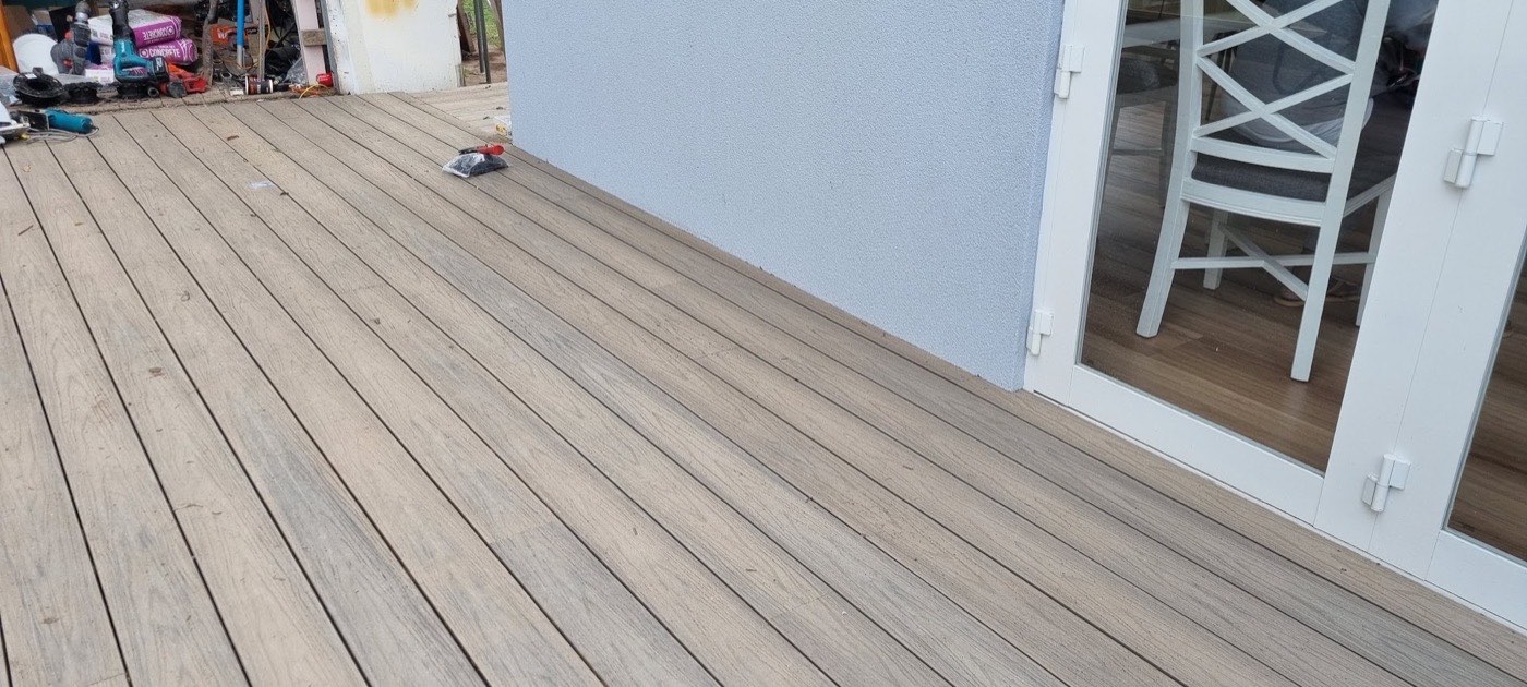 A completed timber deck running along the rear of a home