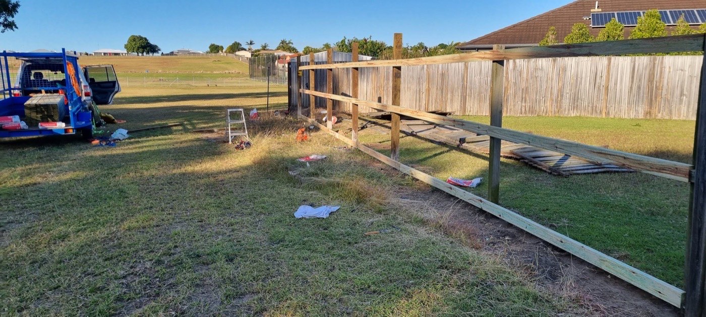 A timber paling fence being built along a boundary, with posts already set