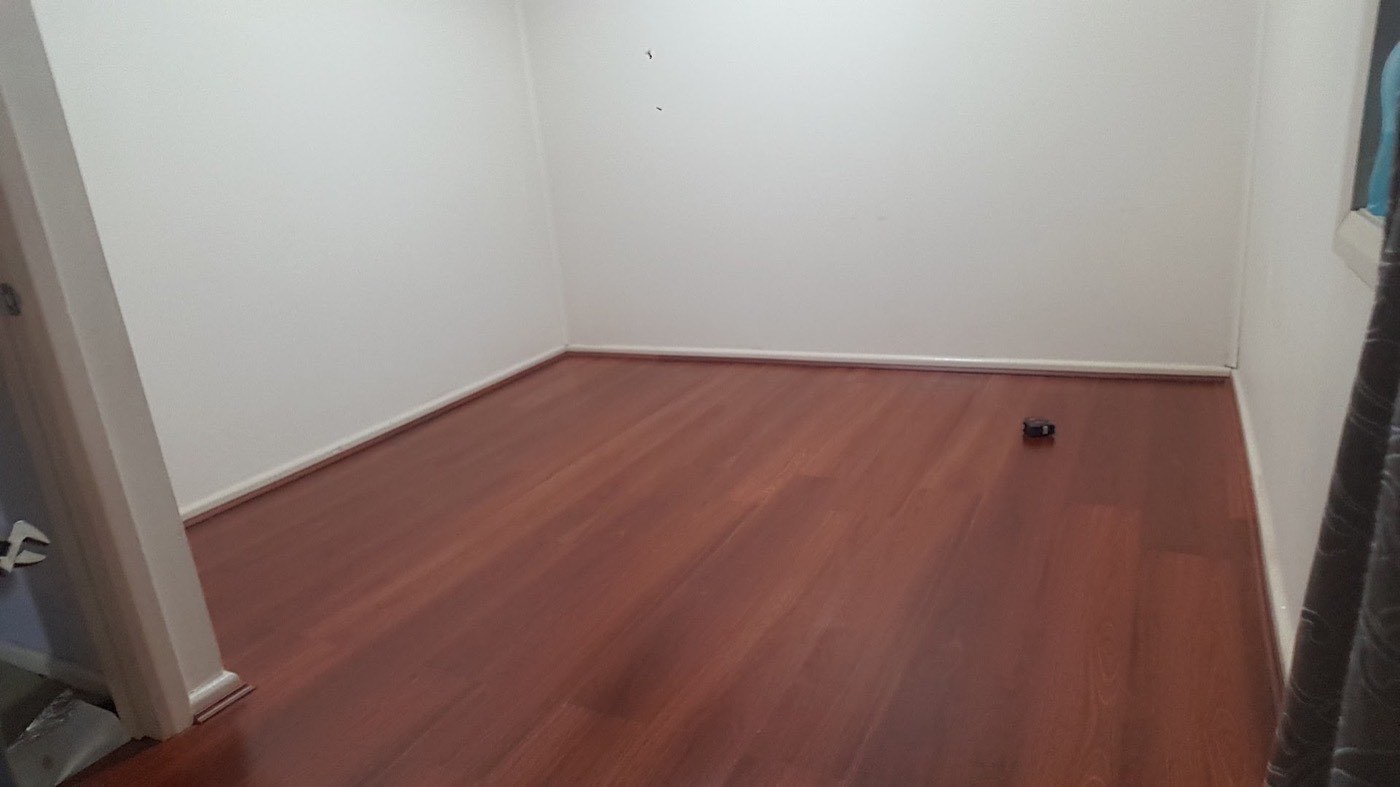 A room with a polished hardwood timber floor and freshly painted walls