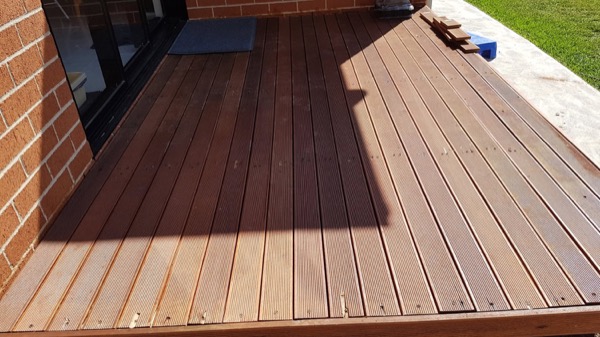 Newly laid hardwood decking boards beside a doorway