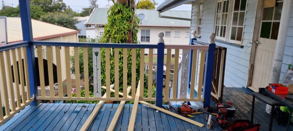 A part-built timber balustrade on a veranda, with tools nearby