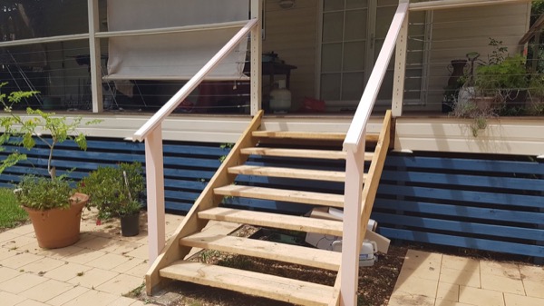 A new set of timber stairs built against a weatherboard house