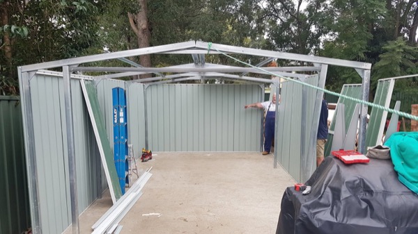 The steel frame of a garden shed standing on a concrete slab