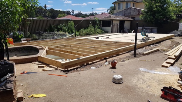 A deck frame set out on a levelled backyard