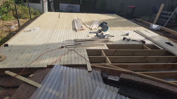Decking boards being laid across a new deck frame