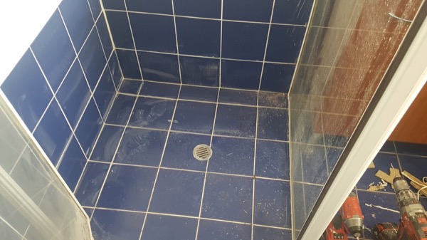 A tiled shower recess with a fitted waste outlet in the floor