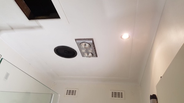 A bathroom ceiling with a new exhaust fan and downlight fitted