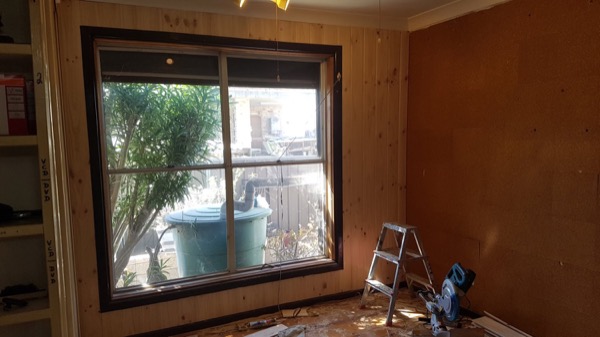 A room being lined with timber boards, with a ladder in place