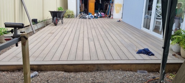 A timber deck with tools and a wheelbarrow still on site