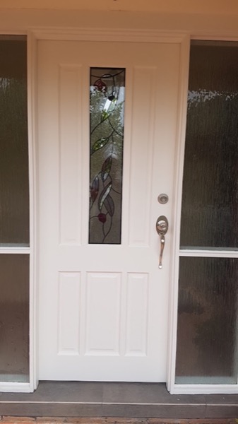 A white timber front door fitted in its frame