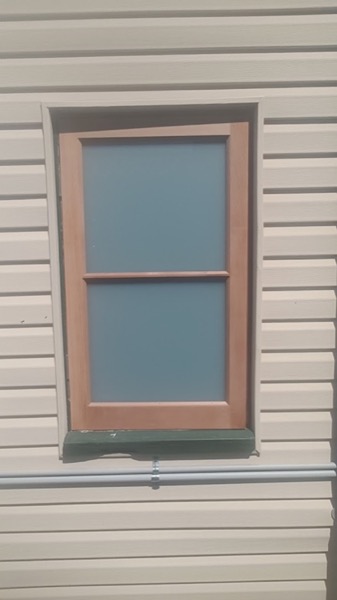 A finished window fitted into a weatherboard wall