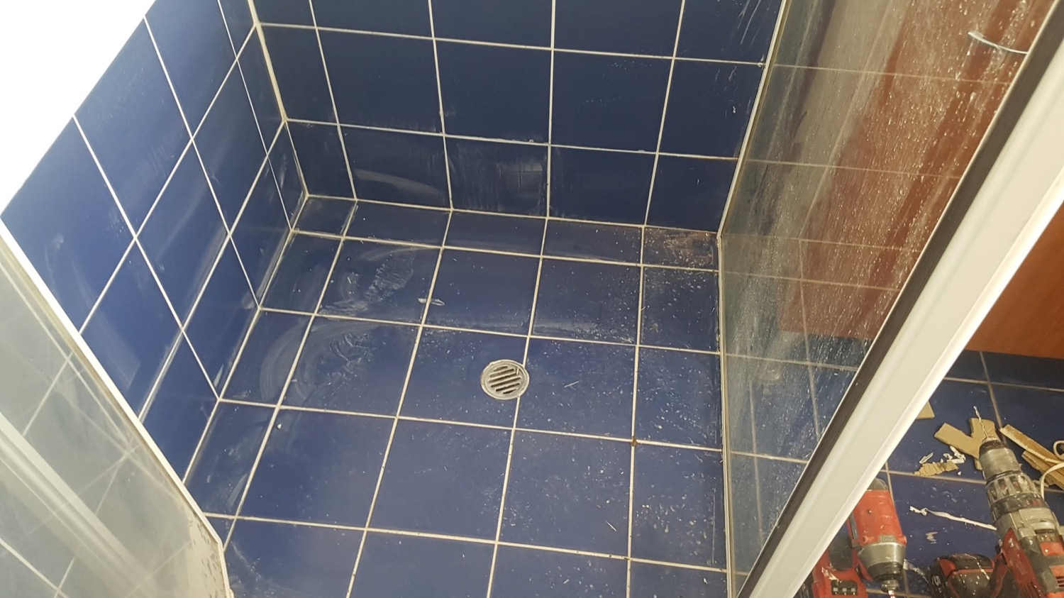 A tiled shower recess with a fitted waste outlet in the floor
